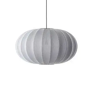 Oval lampe med strikket tekstur, sølvfarvet og enkel, hænger fra loftet i en ledning.
